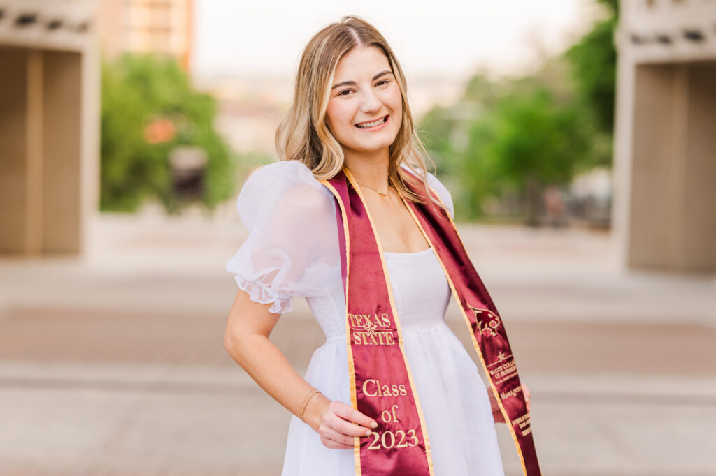 Texas State University senior in front of the Arch. 