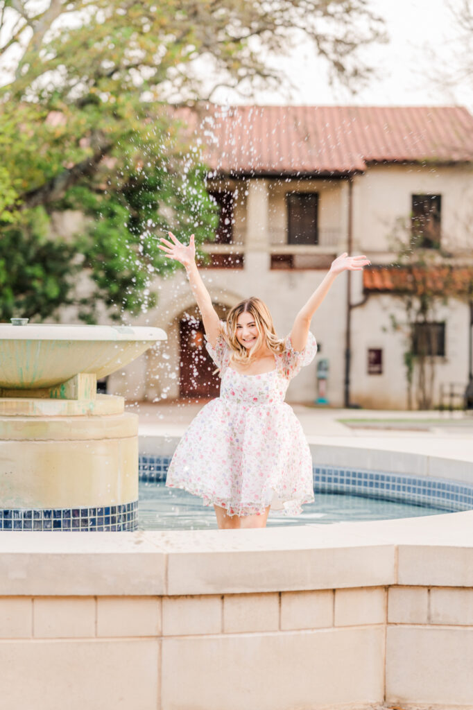 Texas State Universtiy Senior splashing water from the fountain. 