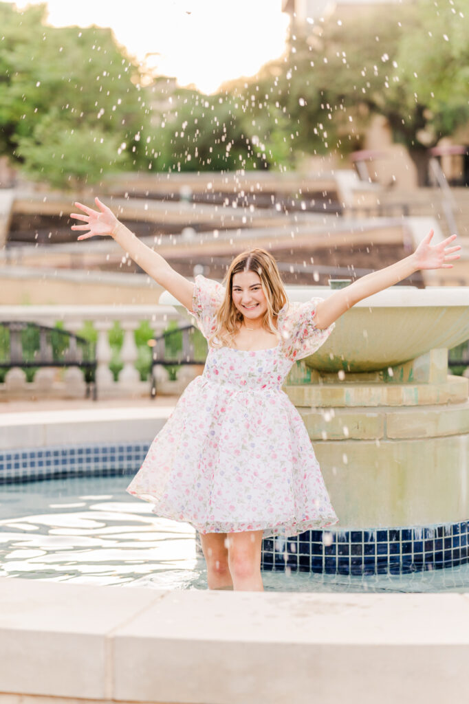 Texas State Universtiy Senior splashing water from the fountain. 