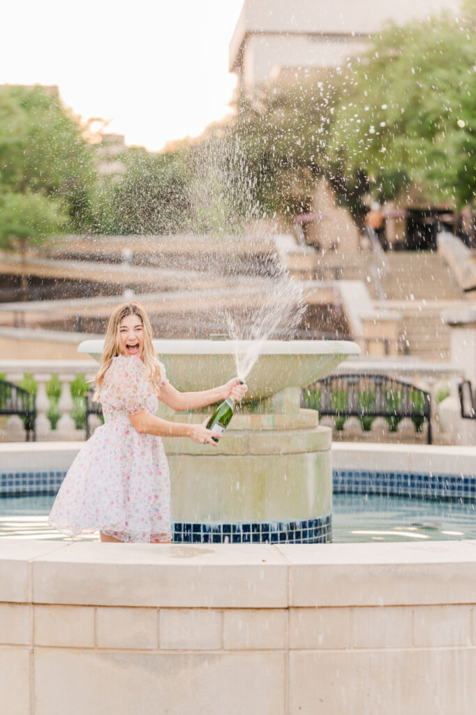 Texas State Universtiy Senior does champagne pop in the fountain. 