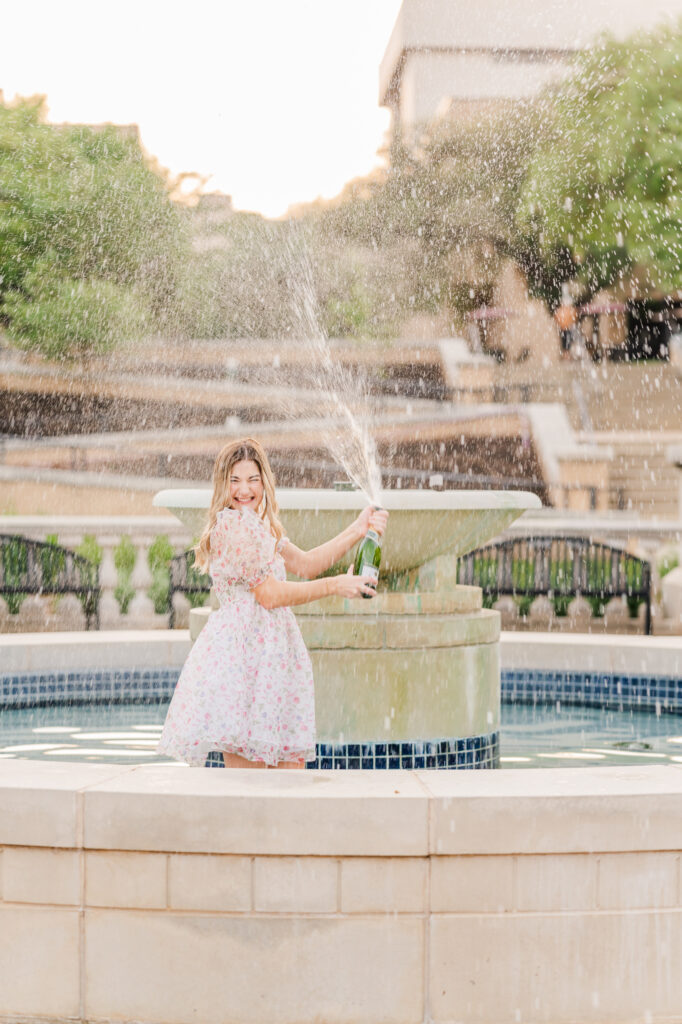 Texas State Universtiy Senior does champagne pop in the fountain. 