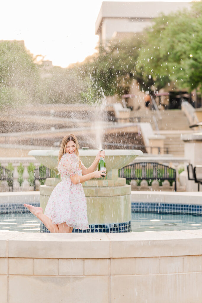 Texas State Universtiy Senior does champagne pop in the fountain. 