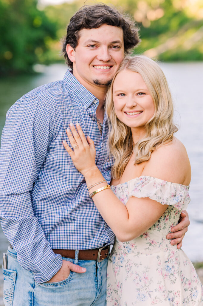 Engaged couple pose in front of Gruene River