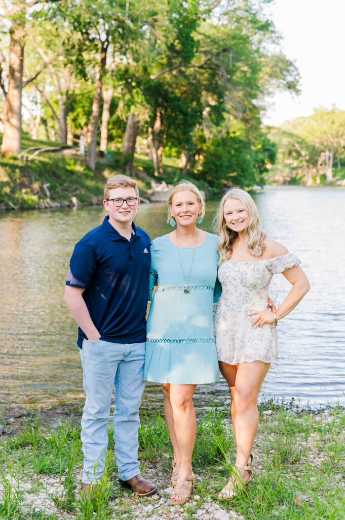 Mom poses with kids in front of river property in New Braunfels