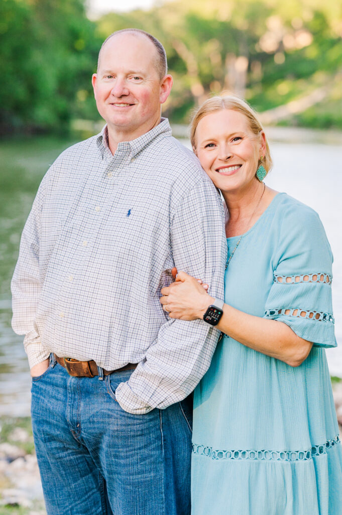 Husband and wife pose in front of Gruene River