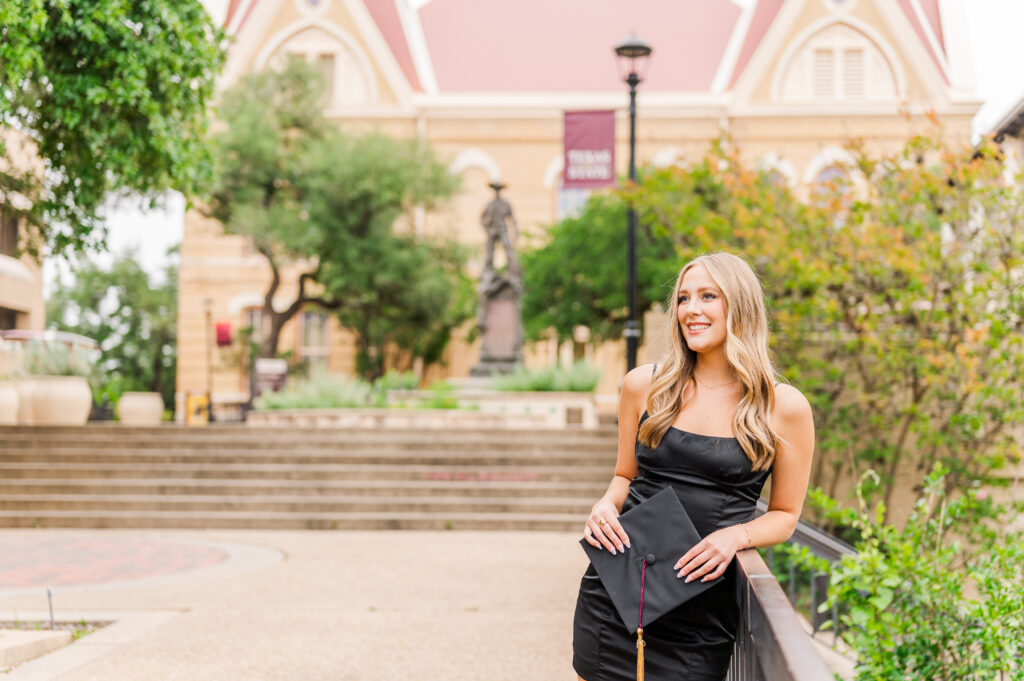 Texas State senior in front of Old Main