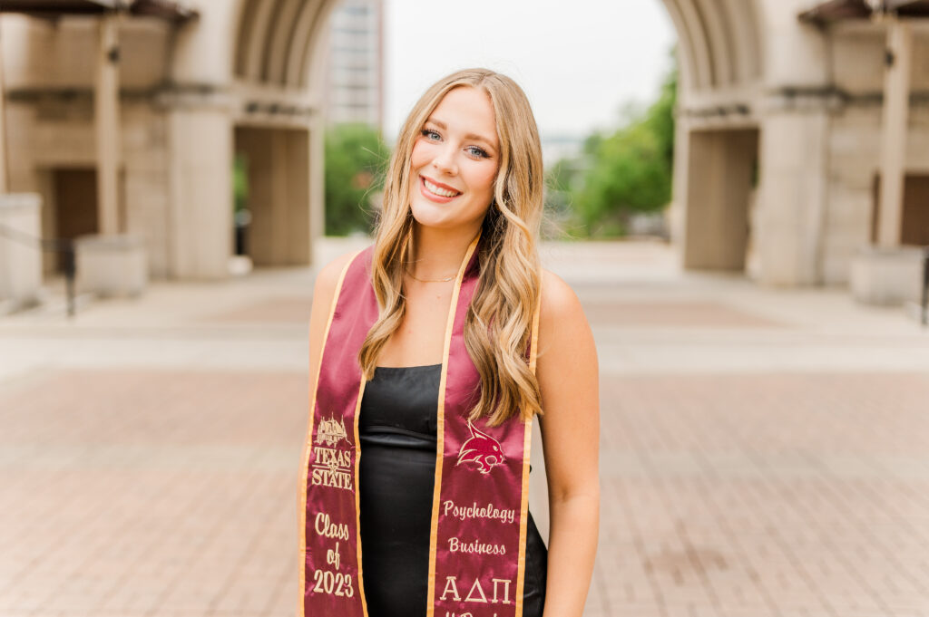 Texas State Senior posing by the Arch 