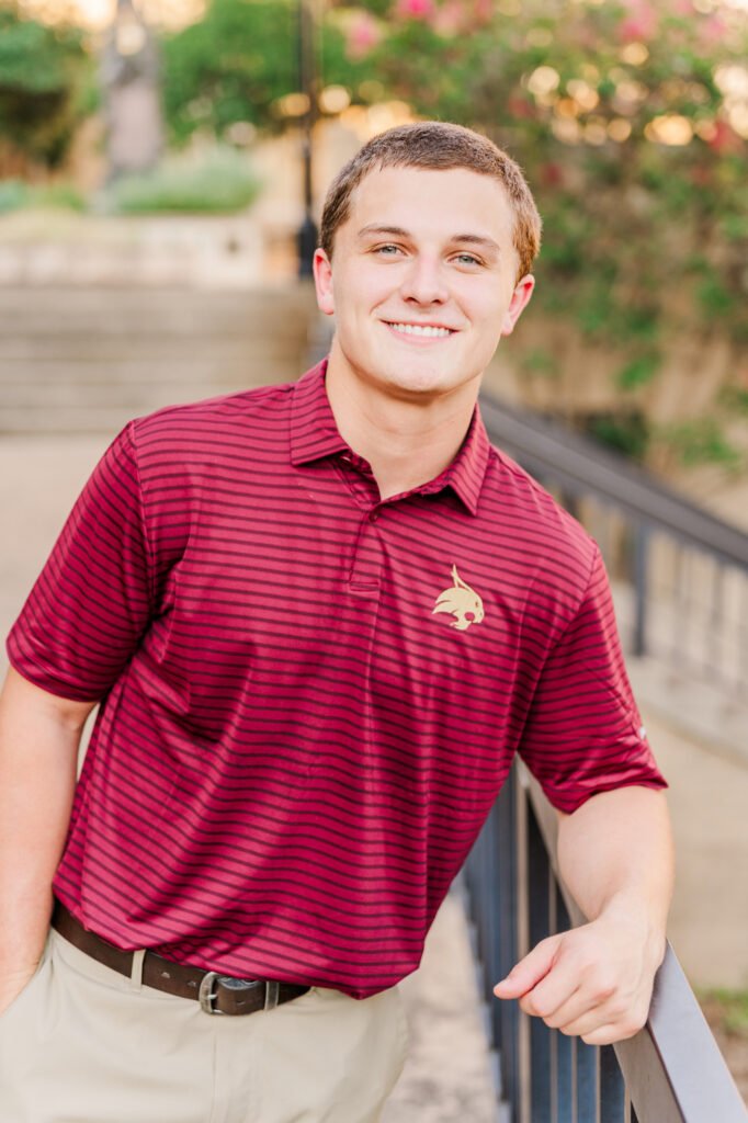 leaning in front of Old Main for his Texas State University Portraits