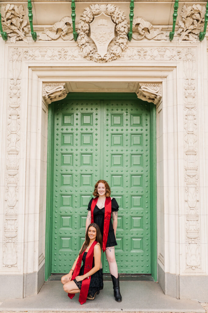 Friends pose in front of green door for their UT Austin graduation session
