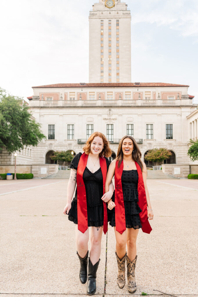 Friends walking in front of UT Austin 
Tower during their graduation session
