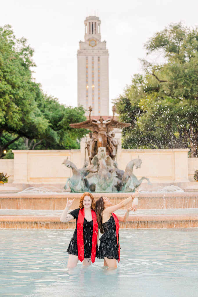 Champagne pop by UT graduate in fountain during UT Austin graduation session
