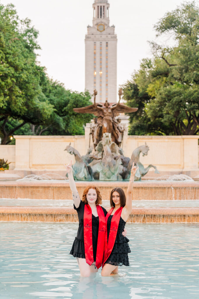 Graduates pose on little field fountain during their UT Graduation session