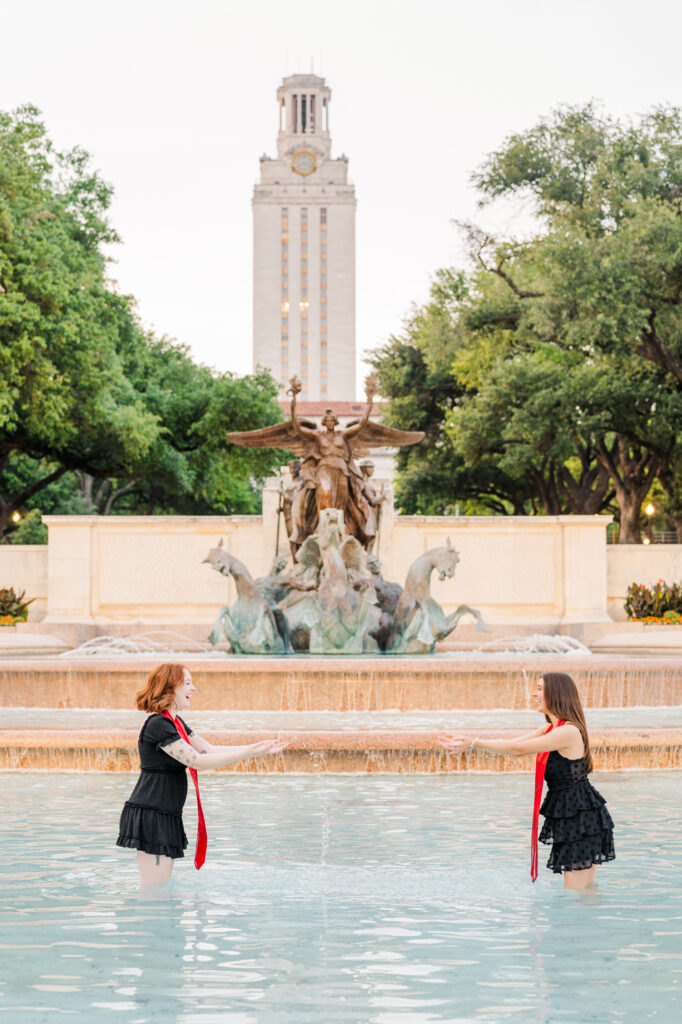 Graduates tossing water in Little Field fountain for their UT Austin Graduation session